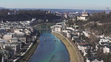 Salzburg, Avusturya 'nın hava manzarasında Salzburg Katedrali, Salzach Nehri, köprüler ve çevreleyen tepeler pürüzsüz bir hareketle.