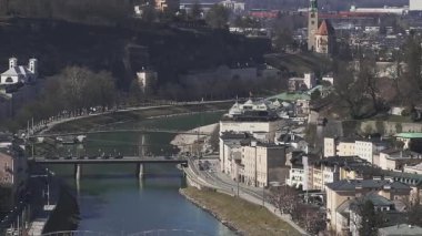 Salzburg, Avusturya 'nın hava manzarası Salzburg Nehri, Salzburg Katedrali, Hohensalzburg Kalesi, köprüler ve çevresini yavaş çekimde gösteriyor..