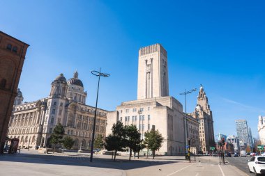 Liver Binası, Liverpool Limanı Binası ve Georges Rıhtım Havalandırma Kulesi 'nin bulunduğu Liverpool caddesinin temiz mavi gökyüzü altında görüntüsü.