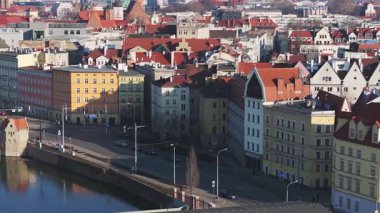 Wroclaw 'ın eski kasabasını süpürmek, taş bir köprü, sakin bir nehir, tarihi bina, kırmızı çatılı kuleler ve ağaçlarla kaplı caddeler sergileniyor..