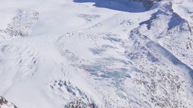 Zermatt kayak merkezinin tepeleri, tepeleri ve buzul arazisi karla kaplıydı. Arka planda Matterhorn dağı vardı..