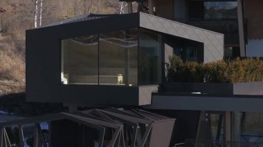 Güney Tyrol, İtalya 'da lüks bir otel, açısal tasarımı, cam pencereleri, çatı bahçesi, teras ve arka planda Dolomite dağları var..