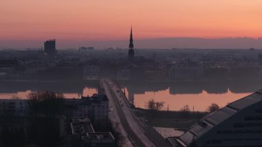 Riga, Letonya üzerinde sakin bir gün doğumu, Eski Kasaba kuleleri, Daugava Nehri üzerinde bir köprü ve sakin bir atmosferde sabah sisi..