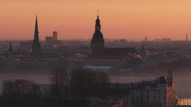 Riga, Letonya 'da sakin bir sabah, gün doğumu şehri aydınlatıyor. Riga Katedrali ve St. Peter Kilisesi 'nin kuleleri sis dağılırken ortaya çıkar..