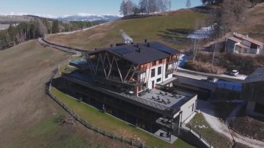 Kamera güney Tyrol, İtalya 'da bir tepe otelinde, modern mimarisi, sonsuz havuzu, Dolomite manzarası, kayak merkezleri ve yakındaki köyleri gösteriyor..