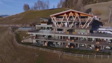 Güney Tyrol, İtalya 'da modern bir otelin havuzu, ahşap aksanları, cam pencereleri ve Dolomitlerin ve kayak merkezlerinin manzarası yer alıyor..