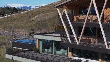 İtalya, Güney Tyrol 'da lüks bir otel. Parlak mimarisi, cam pencereleri, terasları ve Dolomite dağlarına bakan sonsuz havuzu var..
