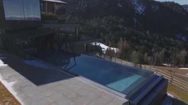 Güney Tyrol, İtalya 'da lüks bir otel, gösterişli tasarımı, terasları, sonsuz havuzu ve Dolomite dağlarının manzarası var. Pürüzsüz döndürme hareketi.