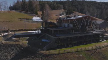 Güney Tyrol, İtalya 'da modern lüks bir otelin havadan çekilmiş görüntüleri. Ahşap kirişler, cam pencereler, sonsuz bir havuz ve Dolomite dağ manzaralı..