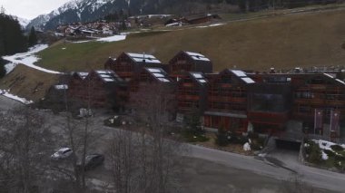 Dolomitler 'de lüks bir otelin havadan görünüşü, Alp tarzı ahşap cepheler, eğimli çatılar ve yavaş yavaş dışa doğru hareket eden kar içeriyor..
