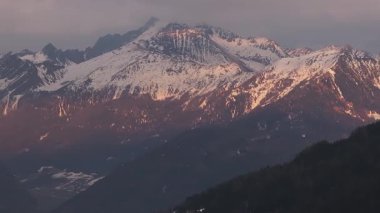 Karla kaplı Dolomitleri, sık ormanları ve engebeli bir dağ vadisine kurulmuş lüks bir Alp tarzı oteli süpüren hava manzarası..