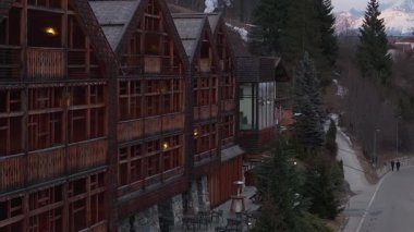 Dolomitler 'deki lüks bir otelin havadan çekilmiş görüntüsü. Çevresi hep yeşil ağaçlarla çevrili, virajlı bir yol ve görülebilir oturma alanları var..