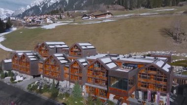 Pürüzsüz insansız hava aracı uçuşu lüks bir Alp tipi otel, karlı dağlar, yemyeşil ormanlar, dolambaçlı bir yol ve yakınlardaki bir dağ köyü ortaya çıkardı..