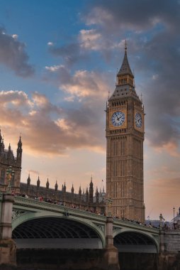 Elizabeth Tower, nam-ı diğer Big Ben, Westminster Sarayı 'nın yanında yer alır. Westminster Köprüsü Thames Nehri 'ni dramatik bir gökyüzünün altında geçiyor..