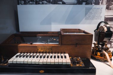 1907 Menkul Kıymetler Borsası, ahşap kaplama, klavye arayüzü ve cam altında görünür mekanizmalar içeren bir telgraf, bir müze sergisinde sergilenmektedir..