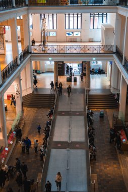 Londra 'da merkezi rampası, merdiveni, süslü parmaklıkları, büyük pencereleri ve mekanı keşfeden insanları olan modern bir bina..