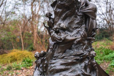 Açık hava bronz heykel, ağaçlar ve çalıların bulunduğu doğal bir park ortamında, ağaçlara oyulmuş çocuklar ve yetişkinler tarafından oyulmuştur..