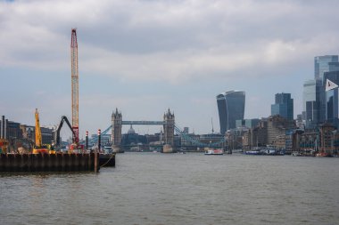 Londra 'daki Thames Nehri üzerindeki Tower Köprüsü manzarası, modern gökdelenlerle Walkie Talkie binası ve nehir kıyısındaki inşaat vinçleri gibi..