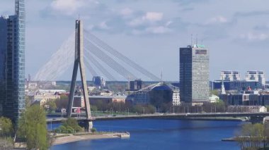 Riga, Letonya manzarası, Daugava Nehri, Riga TV Kulesi ve Vansu Köprüsü. Video, yavaş çekimli ya da yakınlaştırmalı güneşli bir günü gösteriyor..