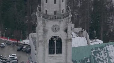 Cortina 'nın Dolomitlerdeki havadan görünüşü Bazilika çan kulesi, karla kaplı çatılar, sarı bir vinç ve orman manzarası..
