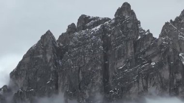 Uçsuz bucaksız Dolomite dağları, karla kaplı yamaçlar, pürüzlü kaya oluşumları ve hareketli bulutlar sakin bir kış manzarası yaratıyor..