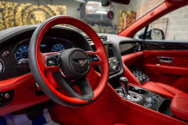 Bentley Bentayga 'nın şatafatlı kırmızı derisi. Karmaşık dikişler, dijital gösterge paneli, krom aksanlar ve lüks bir sergi salonu..
