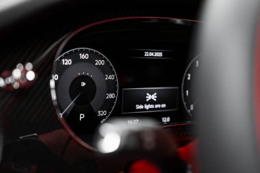 320 km ya da h hız göstergesi olan lüks bir arabanın dijital gösterge paneli, Park 'ta vites, yan ışık tebligatı, ve sportif iç mekanlarda kırmızı aksanlar.