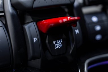 Lamborghini Urus ateşleme sisteminin detaylı görüntüsü. Kırmızı güvenlik kapağı, vites seçici ve parlak siyah bir konutun parlak kontrolleri..