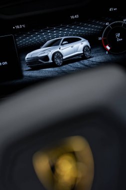 Lüks bir aracın gösterge panelinin detaylı görüntüsü beyaz bir Lamborghini Urus görüntüleme, sıcaklık, zaman, kilometre ve parlak bir şebeke tasarımı gösteriyor.
