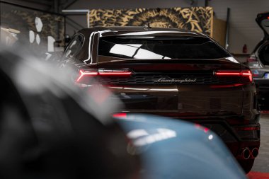 Lamborghini Urus 'un arka manzarası. Işıklı arka lambaları var. Parlak bir çevresi ve dekoratif kaplan desenli paneli var..