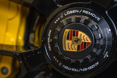Arka planda Porsche arması, gravürleri ve sarı fren kalibresini içeren 2025 model Porsche 911 GT3922 'nin merkez kilit merkezinin ayrıntılı görüntüsü..