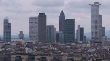 Frankfurt, Almanya 'nın hava manzarası, gökdelenlerin sergilenmesi, Hauptbahnhof' un eğimli çatısı, hareketlilik ve bulutlu gökyüzü altında inşaat vinçleri.