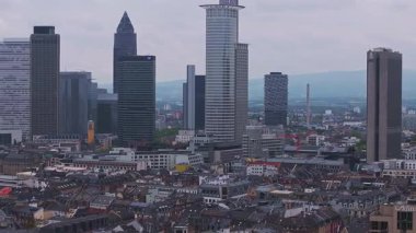 Frankfurt, Almanya 'nın hava manzarası, Merkez İstasyonu, modern gökdelenler, tarihi binalar ve bulutlu gökyüzünün altındaki uzak tepeler ile gökyüzünü gösteriyor..