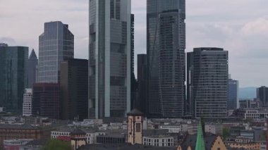 Frankfurt, Almanya 'nın hava manzarası, Commerzbank Kulesi, geleneksel çatılar ve yavaş tavalı yeşil alanlar da dahil olmak üzere modern gökdelenleri gösteriyor.