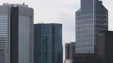 Frankfurt, Almanya 'nın havadan görünüşü, Commerzbank Kulesi gibi modern gökdelenleri gösteriyor. Kamera bulutlu bir gökyüzünün altında ufuk çizgisinde döner..