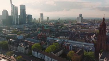 Frankfurt, Almanya 'nın hava manzarası, ana nehri, Eiserner Steg köprüsünü, modern gökdelenleri, tarihi binaları ve hareket eden bir tekneyi gösteriyor..