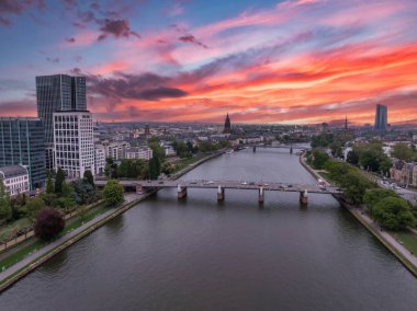 Gün batımında Frankfurt, Almanya 'nın hava manzarası. Ana nehir, bir köprü, Eurotower ve Frankfurt Katedral kulesi ile şehrin içinden geçer..