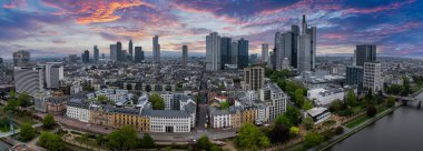 Frankfurt, Almanya 'nın hava manzarası, Commerzbank Tower, Main Tower, ağaç kaplı caddeler ve gün batımında Main River ile birlikte ufuk çizgisini gösteriyor..