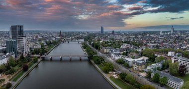 Frankfurt, Almanya 'nın günbatımında ana nehir, köprüler, Frankfurt Katedrali, Avrupa Merkez Bankası ve canlı bir gökyüzünün yer aldığı hava görüntüsü..