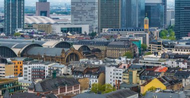 Frankfurt, Almanya 'nın canlı hava manzarası, Merkezi İstasyon, tarihi Avrupa binaları, modern gökdelenler ve sarı bir kilise kulesi sergileniyor..