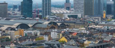 Frankfurt, Almanya 'nın havadan görünüşü, Hauptbahnhof' un kemerli çatıları, yüksek gökdelenler ve yeşil kubbeli sarı bir kilise kulesi..