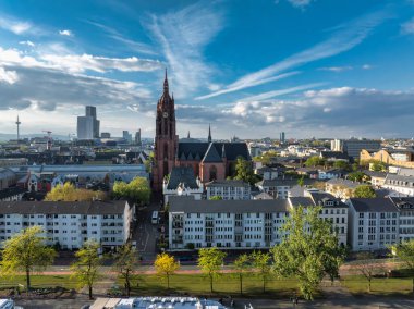 Frankfurt, Almanya 'nın hava görüntüleri, Frankfurt Katedrali' nin kırmızı tuğlası, Main Tower gibi modern gökdelenler ve ön planda ağaçlarla kaplı bir cadde..