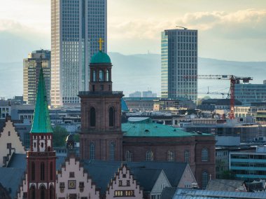 Yeşil kubbesi, geleneksel gökdelenleri, modern gökdelenleri ve bulutlu gökyüzünün altındaki bir inşaat vinci ile birlikte Frankfurt şehir manzarası..