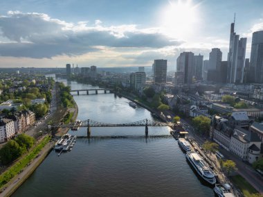 Frankfurt, Almanya 'nın hava görüntüleri, ana nehir, Eiserner Steg köprüsü, modern gökdelenler, geleneksel mimari ve günışığı nehir kıyıları.