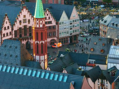 Frankfurt, Almanya 'daki Romerberg Meydanı' nın hava manzarasında Romer, Eski St. Nicholas Kilisesi, kalabalık kalabalıklar ve turuncu bir acil durum aracı yer alıyor..