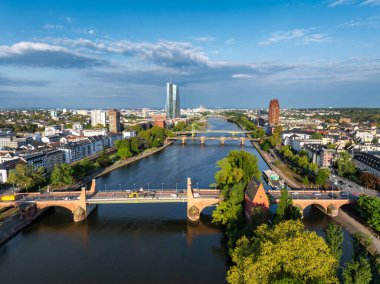 Frankfurt, Almanya 'nın havadan görüntüsü, Ana Nehir, Avrupa Merkez Bankası, Alte Brucke, birden fazla köprü ve açık mavi gökyüzü altında yeşillik.