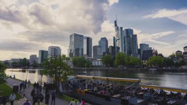 Frankfurt 'un ufuk çizgisi Commerzbank Kulesi ve Main Tower, Main River gezinti güvertesi, yayalar, bisikletçiler ve canlı kenetlenmiş bir tekne toplama..