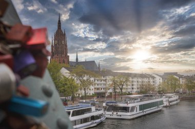 Frankfurt, Almanya manzarası, Gotik tarzı Frankfurt Katedrali, aşk kilitleri olan bir köprü, Ana Nehir ve kenetlenmiş nehir tekneleri.