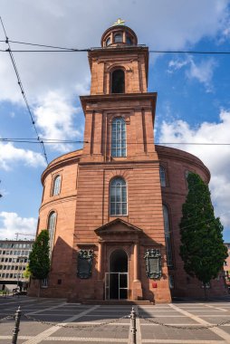 Frankfurt, Almanya 'daki St. Paul Kilisesi' nde kırmızı kumtaşı, yuvarlak bir yapı, altın haçlı merkezi bir kule ve yakındaki kaldırımlı bir plaza yer alıyor..
