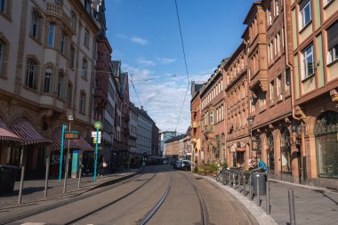 Frankfurt, Almanya 'da sakin bir cadde. Süslü tarihi binalar, kırmızı tuğlalı cepheler, tramvay rayları, üstten kablolar ve park halindeki bisikletler..